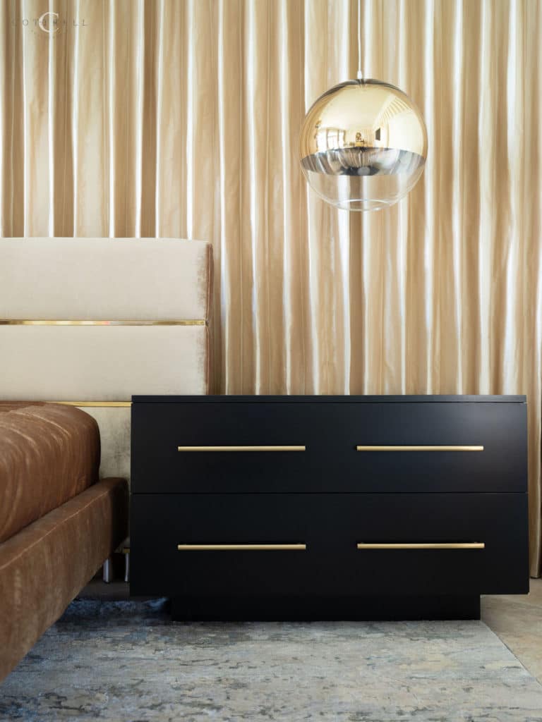 Black bed side table with gold accents.